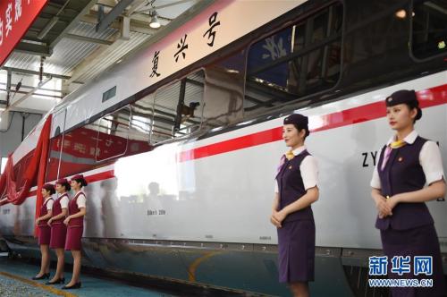 6月25日,乘务人员站在“复兴号”中国标准动车组CR400AF型列车旁。新华社记者 鞠焕宗 摄 图片来源:新华网