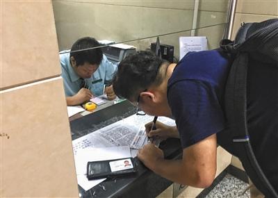 7月7日,东花市北里邮政所,一名顾客正在填写邮寄单。新京报记者 彭子洋 摄
