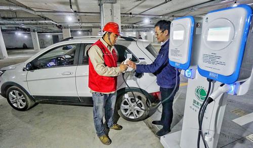 资料图片:10月27日,国网北京电力公司的技术人员在为新能源汽车进行试验充电。新华社记者 李欣 摄